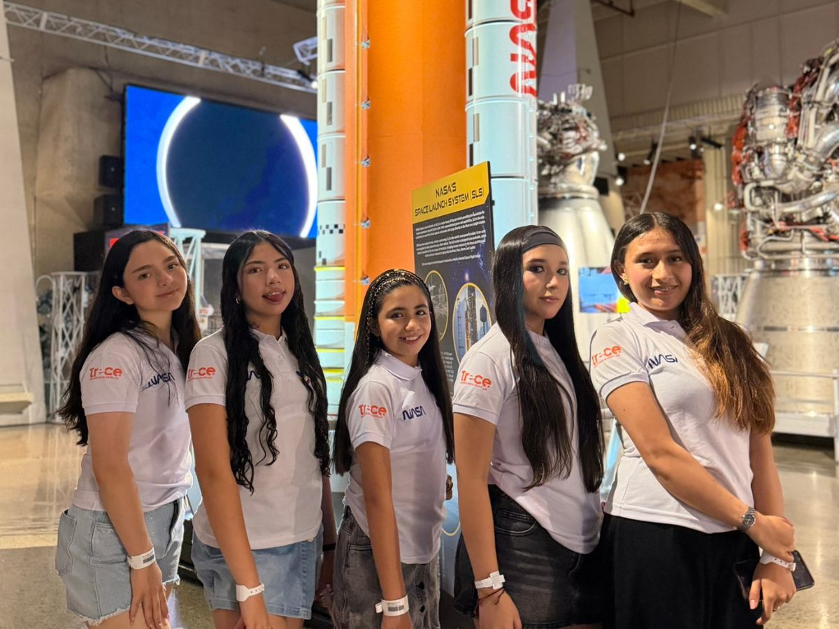 Cinco tripulantes frente al modelo del cohete Space Launch System de la NASA